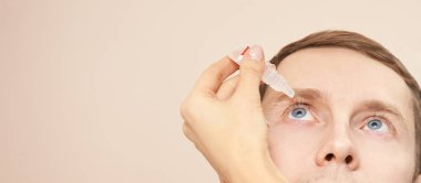 Doktor hasta yüzünün yanında göz damlası tut.