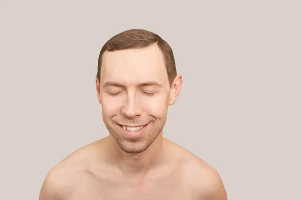 Uśmiechnięty biały człowiek. Portret kosmetyczki. Zamknięte oczy — Zdjęcie stockowe