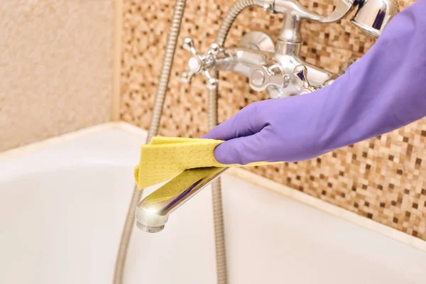 House worker clean bathroom. Purple glove with yellow rag