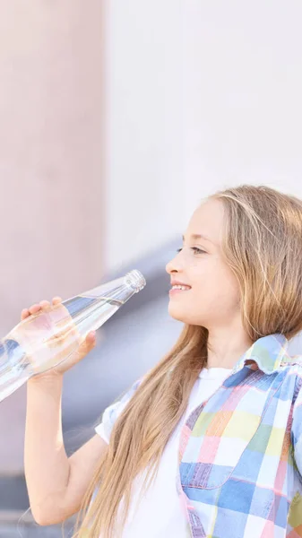 Gadis kecil memegang botol air. Pelatihan luar ruangan. Haus. Gelas minum — Stok Foto