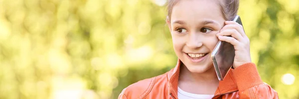 Nettes kleines Mädchen im Gespräch. Handy in Gesichtsnähe halten — Stockfoto