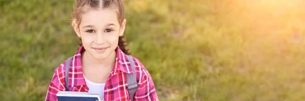 Jong schoolmeisje met rugzak. Lifestyle naar het klaslokaal. Buiten — Stockfoto