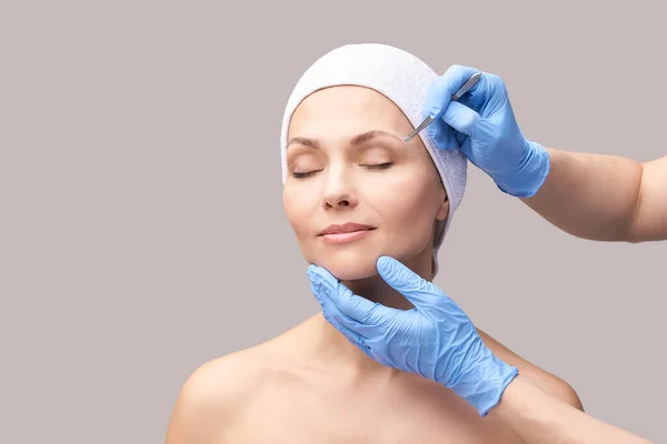 美容师的皮肤护理。脸用镊子面部治疗。妇女皮肤病例程 — 图库照片