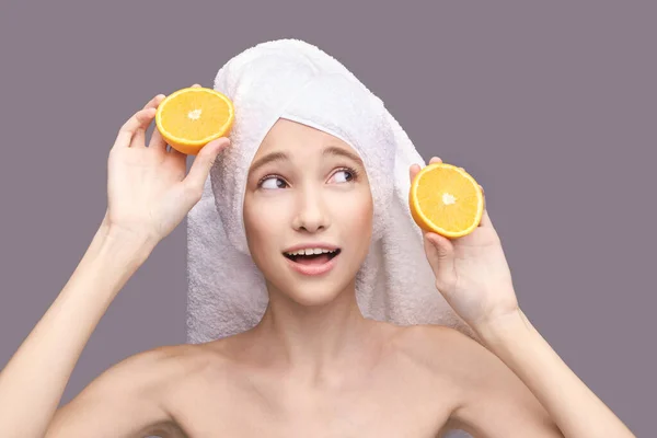 Menina segure a fatia de laranja. Frutas cítricas rosto escondido — Fotografia de Stock