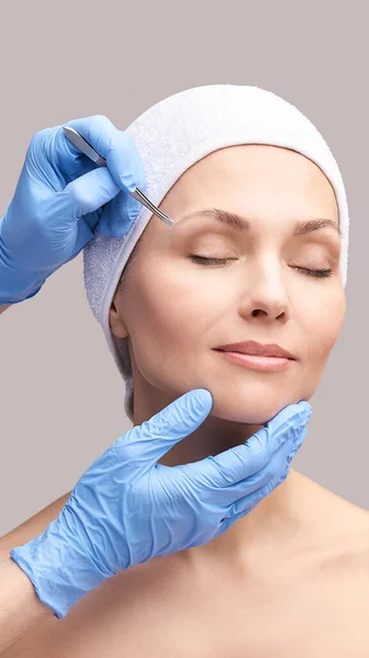 美容师的皮肤护理。脸用镊子面部治疗。妇女皮肤病例程 — 图库照片
