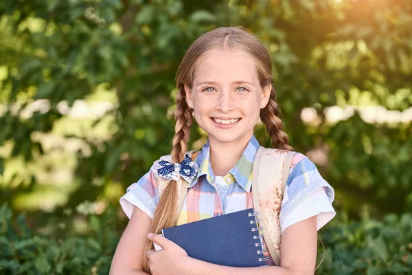 Schöne amerikanische Porträt von Schulmädchen. Vorschulkind hält Buch. Lächelnd — Stockfoto