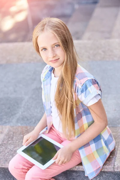 Красивый американский портрет школьницы. Ребенок держит устройство. Образование онлайн — стоковое фото