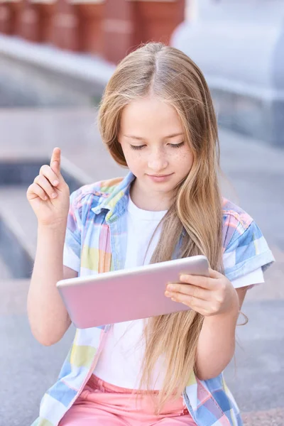 Красивый американский портрет школьницы. Ребенок держит устройство. Образование онлайн — стоковое фото