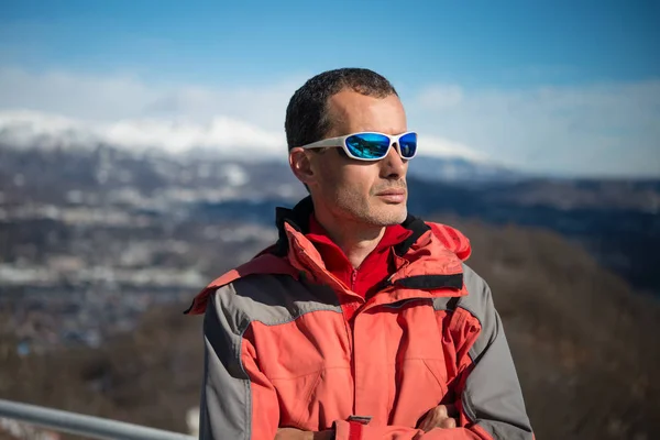 man with sunglasses on the mountains in a beautiful sunny day