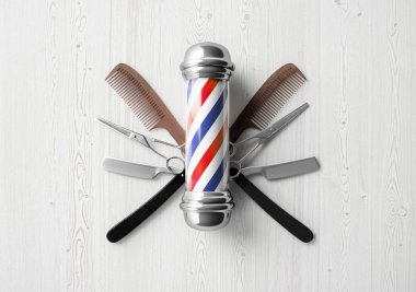 barbers pole with tools on wooden textured background clipart