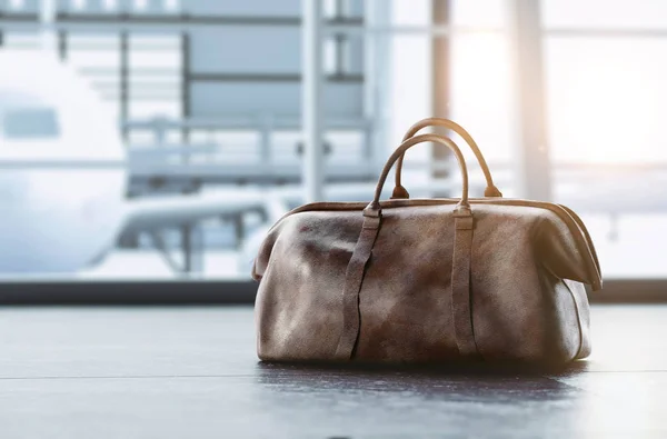 leather hand luggage on floor in airport