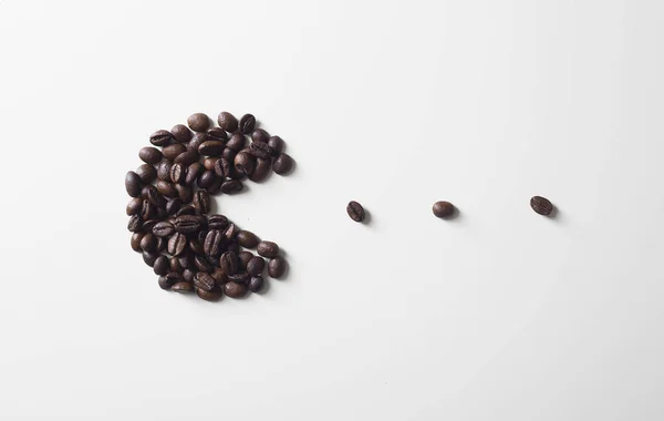 Pacman Silhouette Aus Kaffeebohnen Auf Weißem Hintergrund — Stockfoto