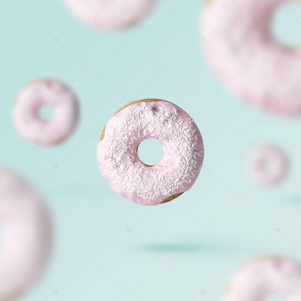 doughnut surrounded by defocused donuts on pastel background