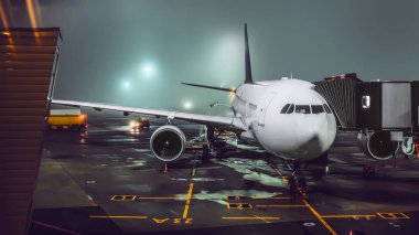 Geceleri ışıklı sisli havaalanında uçak görünümünü