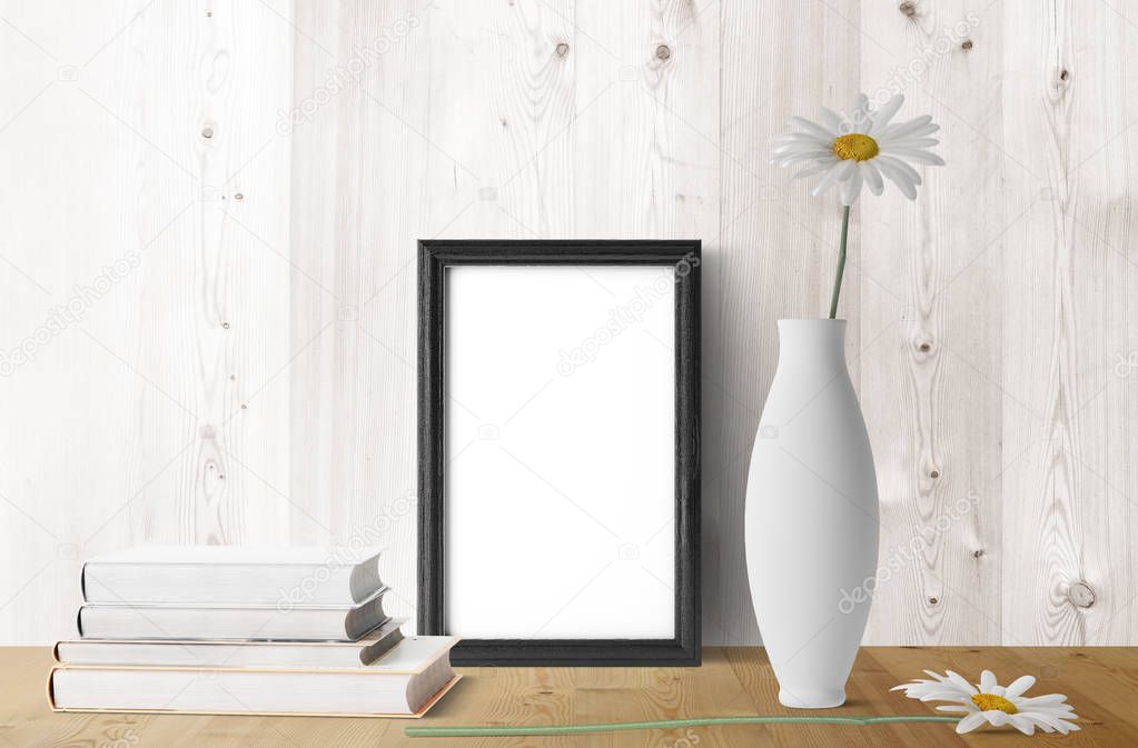 blank frame with chamomile flowers and books 