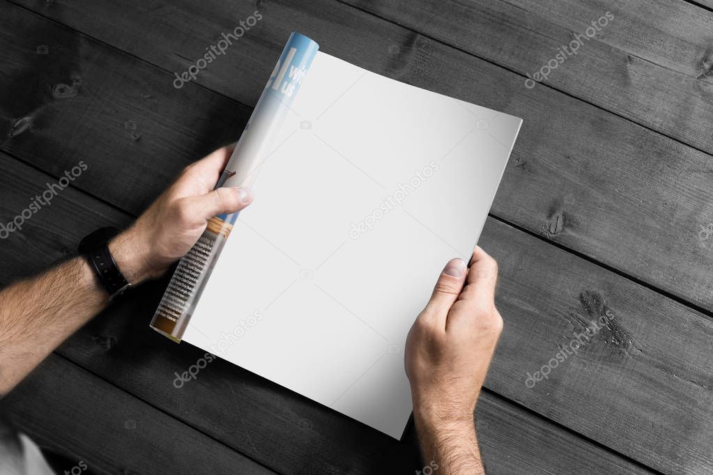 male hands holding magazine with blank sheet