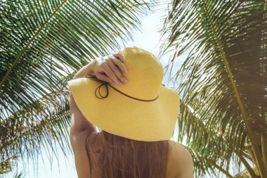 Dikiz tropik bitkiler ile şapkalı kadın