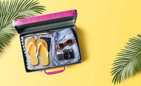 top view of packed travel bag with flip flops and camera