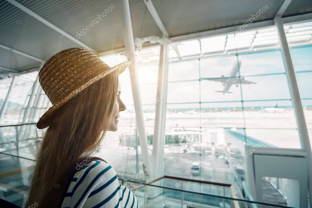girl traveler wearing hat standing in airport