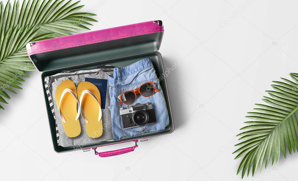 top view of packed travel bag with flip flops and camera