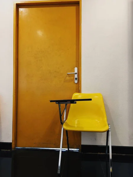 Sarı Sandalye Kahverengi Kapı Arka Plan Olarak — Stok fotoğraf