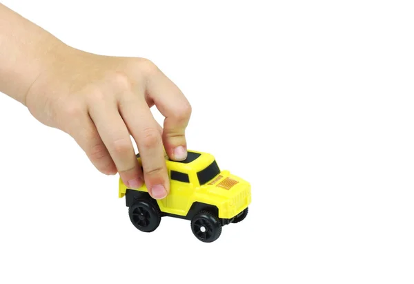 Hand Van Kinderen Met Een Gele Auto Geïsoleerd Wit — Stockfoto