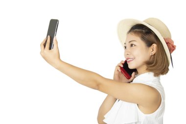 Güzel Çin Americn kadın beyaz bir arka plan üzerinde izole aynı anda iki akıllı telefonlar üzerinde söz