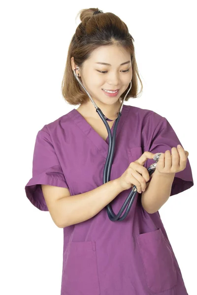 美しいのアジア系アメリカ人の医師や看護師紫のスクラブを着て 白い背景で隔離の聴診器でポーズ — ストック写真