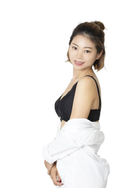 美丽的中国妇女摆在白色的衬衫和一对黑色的内裤和胸罩被隔离在白色的背景 — 图库照片