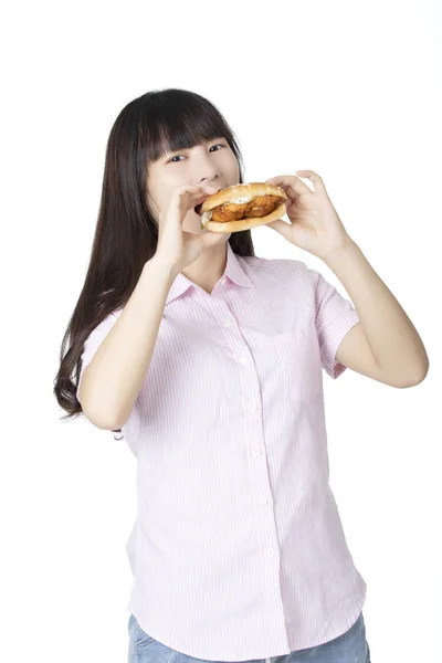 Chinesisch-amerikanische Frau isst Hühnersandwich isoliert auf weiß — Stockfoto