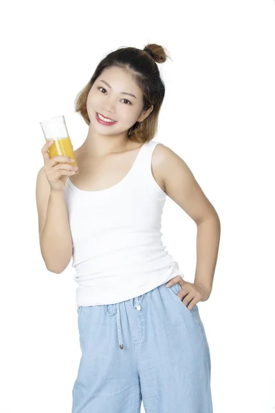 Mulher chinesa bebendo suco de laranja isolado no fundo branco — Fotografia de Stock