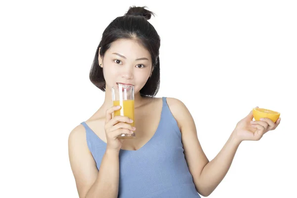 Mulher chinesa bebendo suco de laranja isolado no fundo branco — Fotografia de Stock