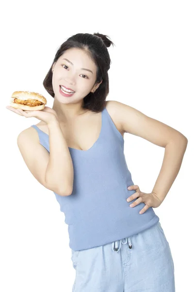 Chinese American woman eating Chicken Sandwich isolated on white — Stock Photo, Image