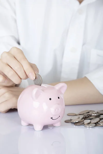 Mão feminina segurando moedas porquinho banco isolado, fundo branco — Fotografia de Stock