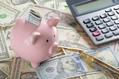 Amerikan banknotları ve sikkeler, hesap makinesi, kalem ve kumbara