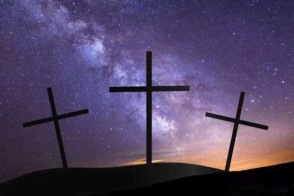 Three crosses on hill top with milky way in background