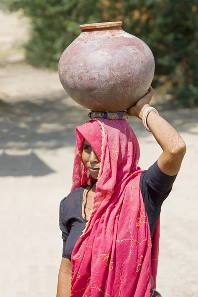 Mujer hindú llevando una jarra en la parte superior de la cabeza Rajasthan India — Foto de Stock