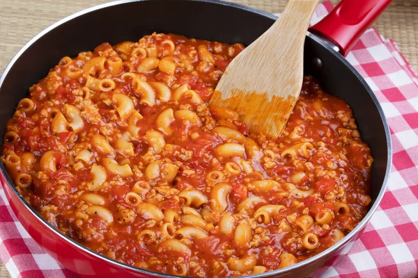 Heerlijke Goulash Noddles Een Rode Koekenpan Met Een Houten Spatel — Stockfoto