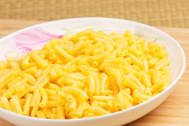 Tabak dolusu lezzetli makarna ve ahşap bir arka planda chesee.