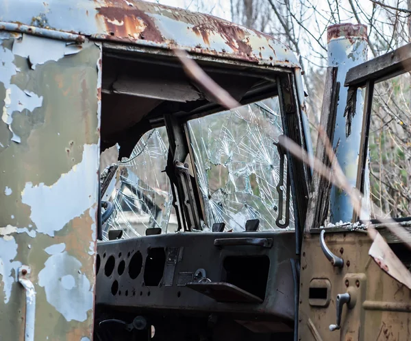 Damaged cabin with broken glass of the abandoned old-style military track,  in forest in Chernobyl Exclusion Zone