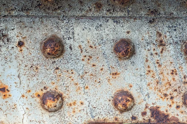 Painted rusty metal beam with four spherical rivets heads, textu