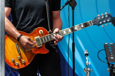 Siyah nötr t-kısa genç adam sarı elektrik gitar çalar 