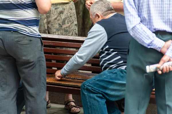 Mehrere alte Männer spielen ein Domino-Spiel auf der Parkbank der Stadt — Stockfoto
