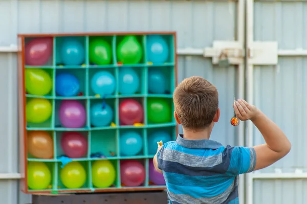 男孩在后院玩气球飞镖 - 一个盒子或设置与合作 — 图库照片