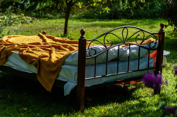 Una cama se queda en el jardín verde, al aire libre, cubierto con blanke amarillo — Foto de Stock
