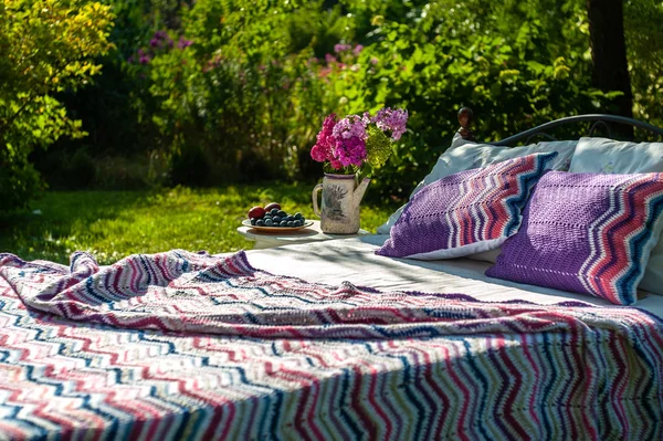 En säng stannar i Green Garden, Utomhus, täckt med färgglada blan — Stockfoto