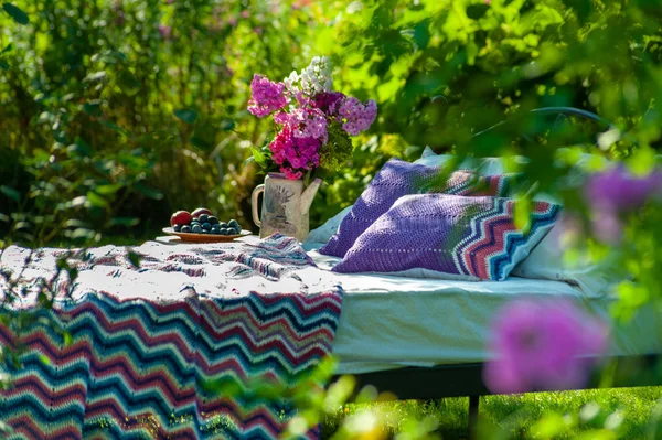 Una cama se queda en el jardín verde, al aire libre, cubierto de colorido blan — Foto de Stock