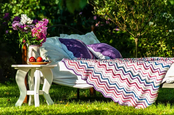 En säng stannar i Green Garden, Utomhus, täckt med färgglada blan — Stockfoto