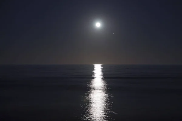 Big full moon is rising above the sea at night. Lunar light reflected on the water. Lunar path. Ocean. — Stock Photo, Image