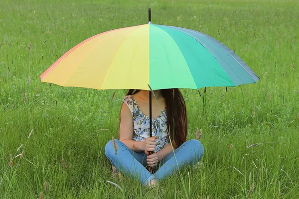 Женщина Сидит Цветным Радужным Зонтиком Зеленом Травяном Поле Брайт — стоковое фото